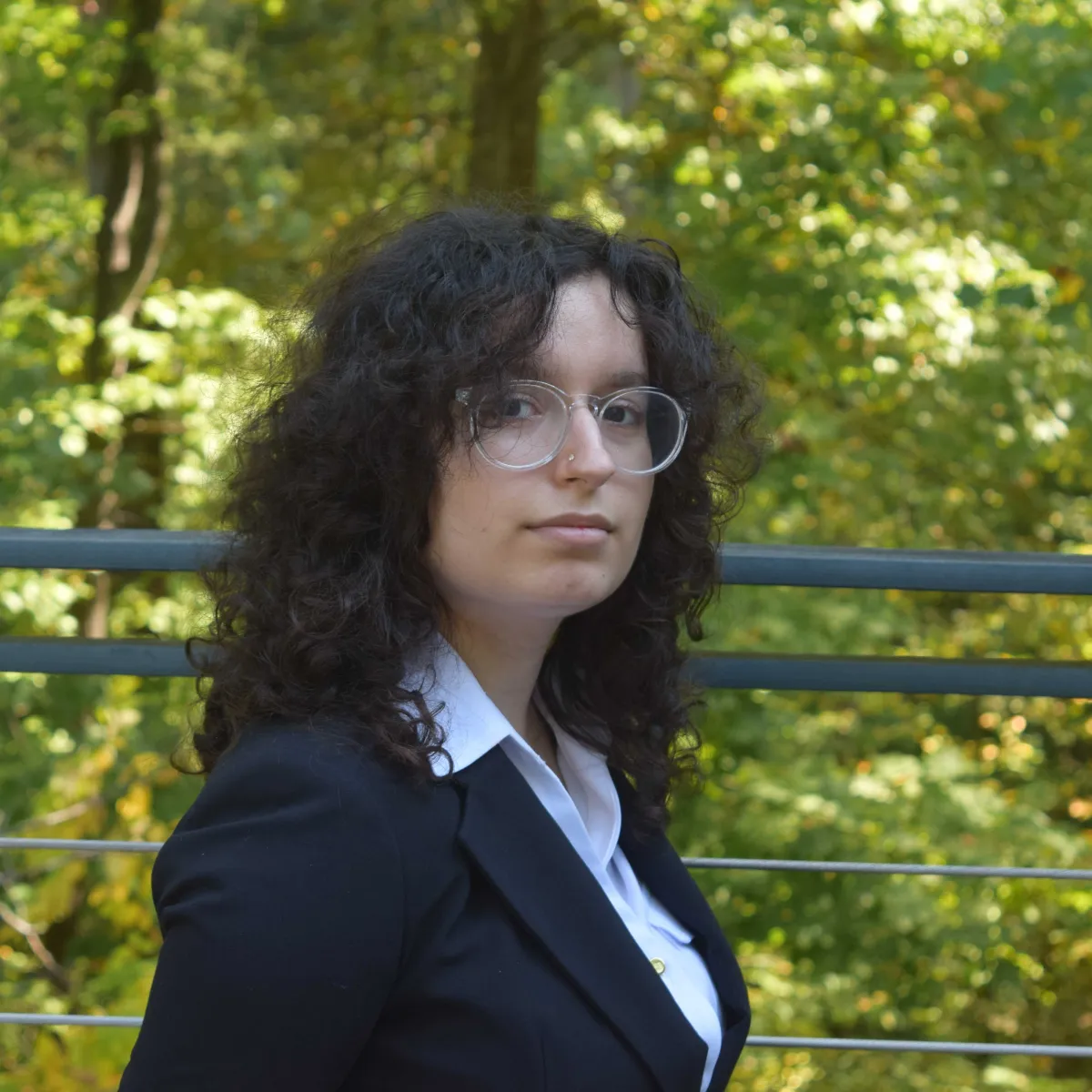 Sara Behnam looking seriously into the camera in front of trees