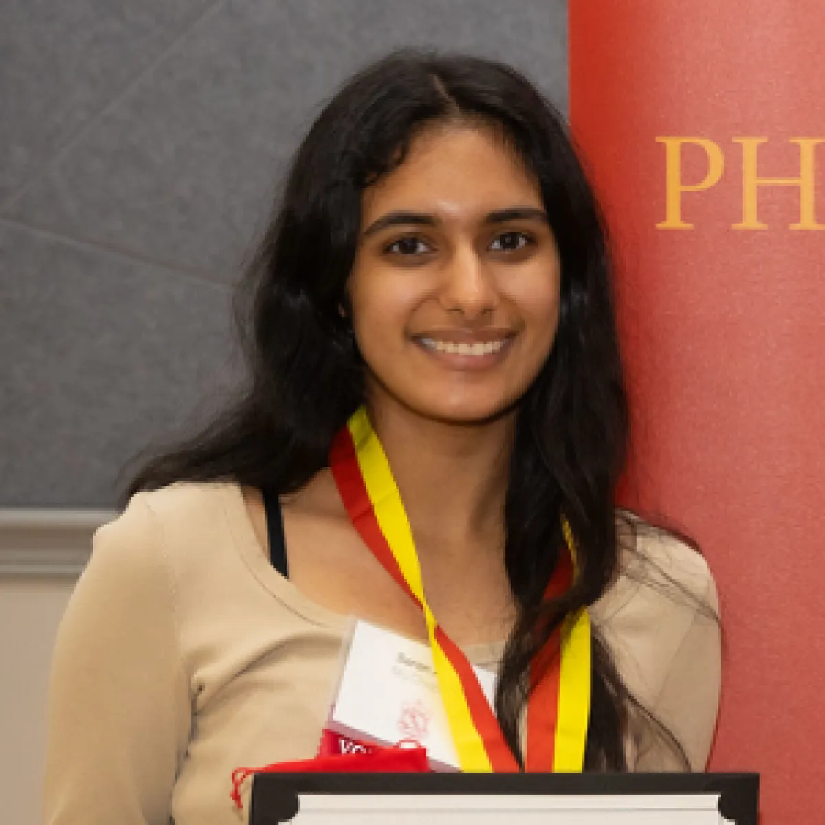 Saran Jolly smiling with a plaque in hand